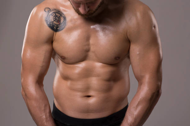 Abdominal workout Athlete checking progress on his abs wrestlers uniform stock pictures, royalty-free photos & images
