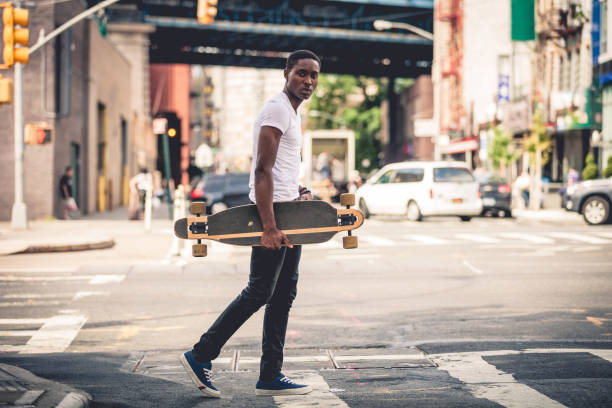 istock Man riding a longboard skateboard in New York City 908028662
