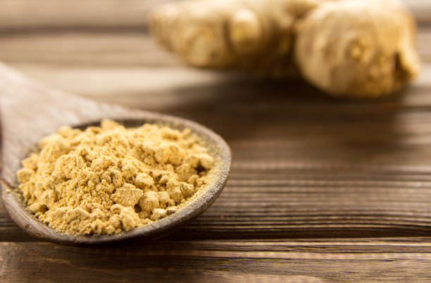 istock Ginger powder in wooden spoon on wooden table. 908030362