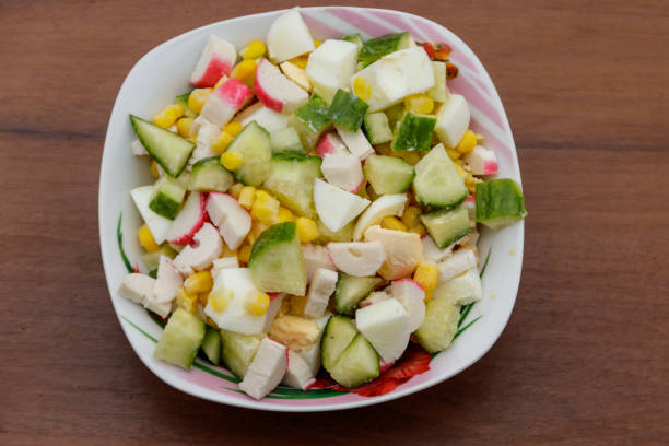 istock Salad with crab sticks, sweet corn, cucumber and eggs on wooden table 908032162