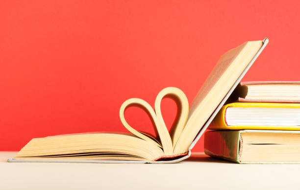 istock Heart from book pages on red background. Free copy space. 908034170