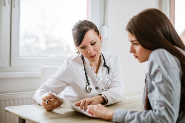 Charming female doctor giving advice to a female patient. Charming female doctor giving advice to a female patient. womens issues photos stock pictures, royalty-free photos & images