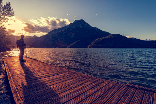 istock Hiker looking sunset over the lake. 908034422