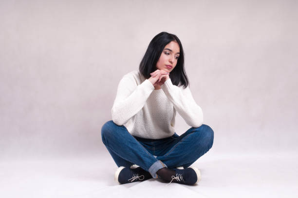 istock sad girl sits on the floor in jeans 908035694