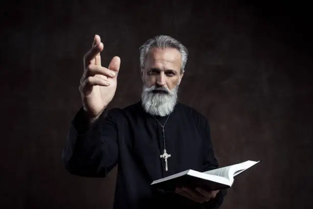 Priest holding Holy Bible