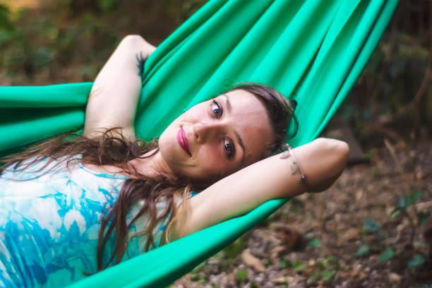 istock Young beautiful woman relaxing in hammock 908039252