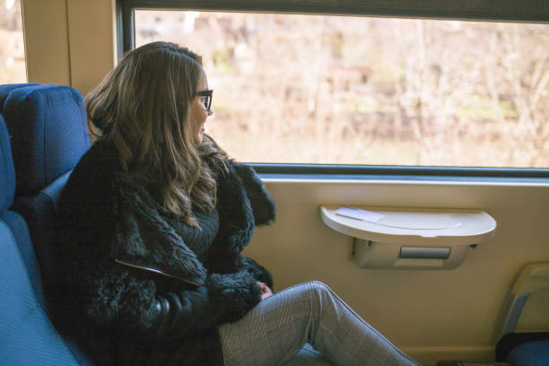 istock Young sad woman looking through the train window. 908039732