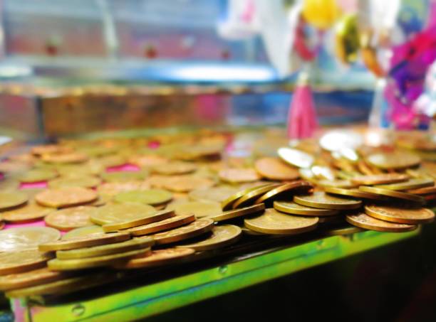 anticipation: two pence coins teeter on the edge inside a coin pusher machine - british currency coin two pence coin british coin imagens e fotografias de stock