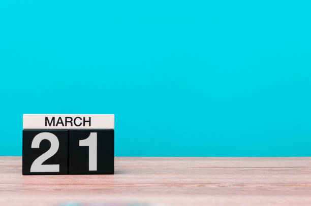 istock March 21st. Day 21 of month, calendar on table with turquoise background. Spring time, empty space for text 908043422