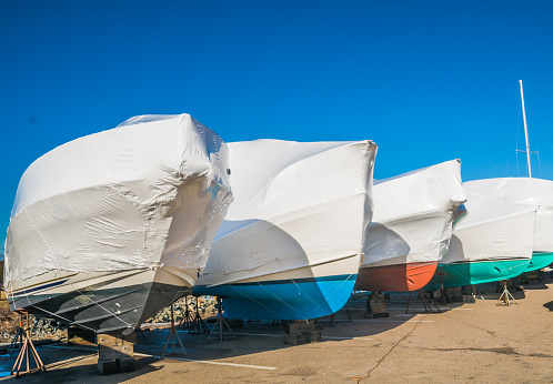 Yachts have been pulled from the water and shrouded with white shrink wrap for winter storage at the Sandwich Marina on Cape Cod.