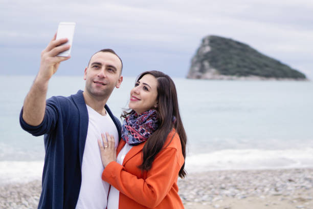istock Selfie : Couple capturing fun moments on the beach 908048134