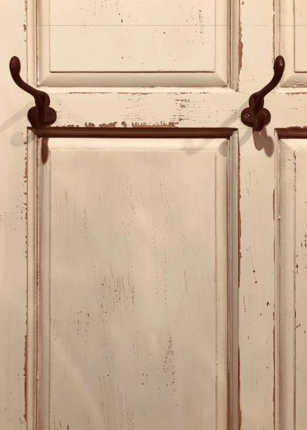istock Beige shabby chick wooden wall with two rusty coat hooks 908055238