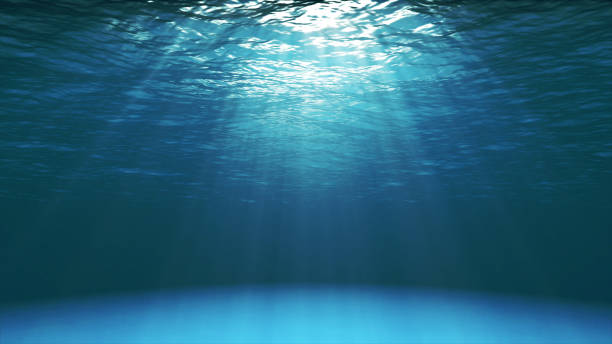 Dark blue ocean surface seen from underwater Dark blue ocean surface seen from underwater. Waves underwater and rays of sunlight shining through deep stock pictures, royalty-free photos & images