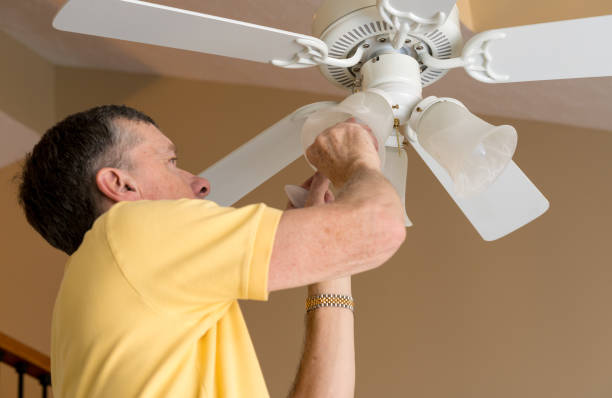 istock Senior caucasian man replacing bulb in ceiling fan and light 908063390