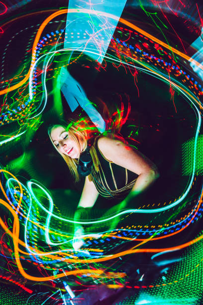 Female DJ Artist Mixing Music at Techno Party Female DJ Artist Mixing Music at Techno Party, Motion Trails dance  electronic music photos stock pictures, royalty-free photos & images