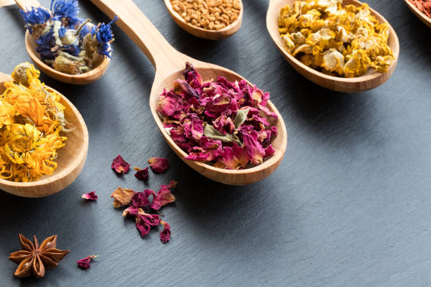 istock Herbs on wooden spoons on a dark background with copy space 908067058