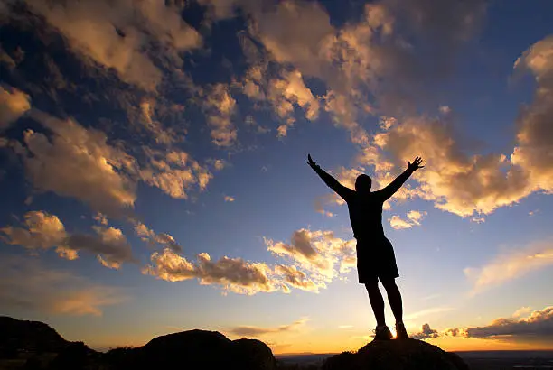 Photo of silhouette man arms raised sunset sky landscape