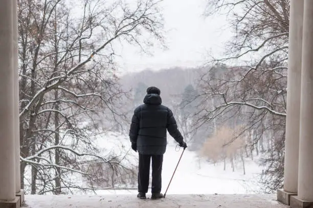 The man is an elderly pensioner standing in the arch with his back. In the winter in the park. Tsaritsyno, Moscow.