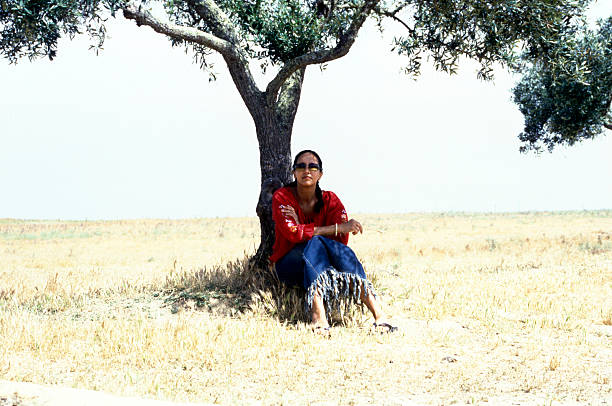 women sitting under tree stock photo