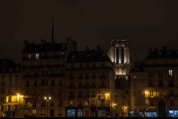 katedra notre dame de paris otoczona średniowiecznymi budynkami mieszkalnymi typowymi dla ile de la cite w paryżu, francja, w zimowy wieczór, wzięta z nabrzeży sekwany - paris france notre dame night ile de la cite zdjęcia i obrazy z banku zdjęć