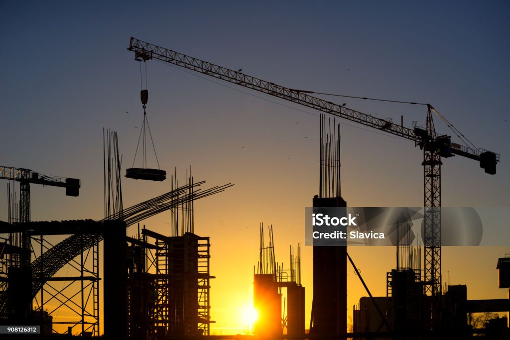 Silhouette of modern construction site at dusk Silhouette of modern construction site with couple of tower cranes at sunset. Skyscraper Stock Photo