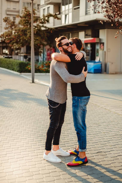 istock Friends hugging in the street and smiling 908126732