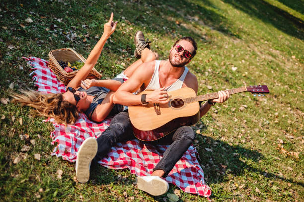 istock Couple singing and dancing in a park 908126738