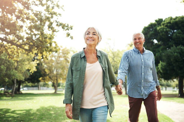Staying in love is something very special Shot of a happy senior couple going for a walk in the park walking stock pictures, royalty-free photos & images