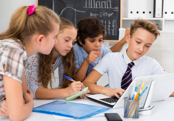 istock Boys and girls talking near the notebook 908130950