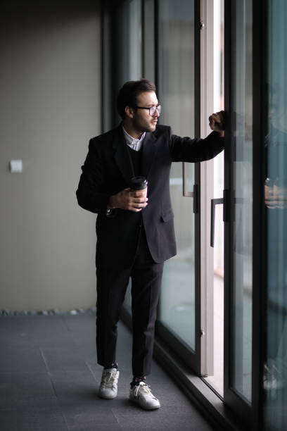 istock Young adult looking through window 908131756