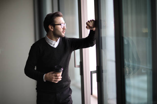 istock Young adult looking through window 908131778