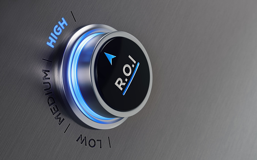 Push button on brushed metal surface. There is ROI text and an arrow symbol on the button. The arrow is pointing high text on metal surface. Horizontal composition with copy space and selective focus.