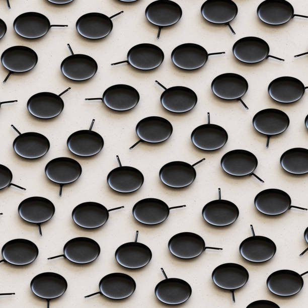 istock Isometric Iron Frying Pans in a Tight Grid on a Simple Concrete Surface 908150924