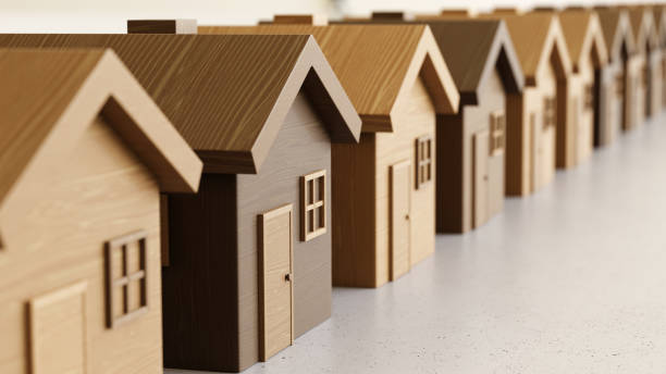 istock Linear Array of Toy Wooden Houses on a Light Gray Surface 908151374