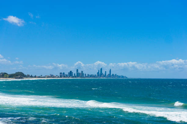 istock Beautiful ocean with soft waves and cityscape on the background 908154452