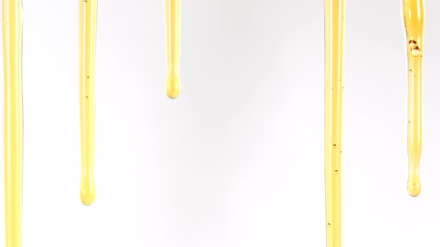 Close up golden sweet honey dripping line on the white background , 4K Dci resolution