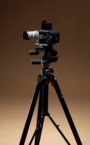 studio shot of aprofessional camera on stand in brown background