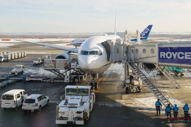 sapporo, japon - 14 janvier 2017 : passagers avion jet boeing 777-200 exploité par all nippon airways (ana) est chargée vers le haut avec la cargaison à l’aéroport new chitose (iata : cts ; oaci : rjcc) - new chitose photos et images de collection