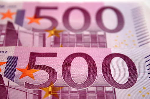 Close-up image of the Euro symbol at the centre of a collection of modern Euro notes.