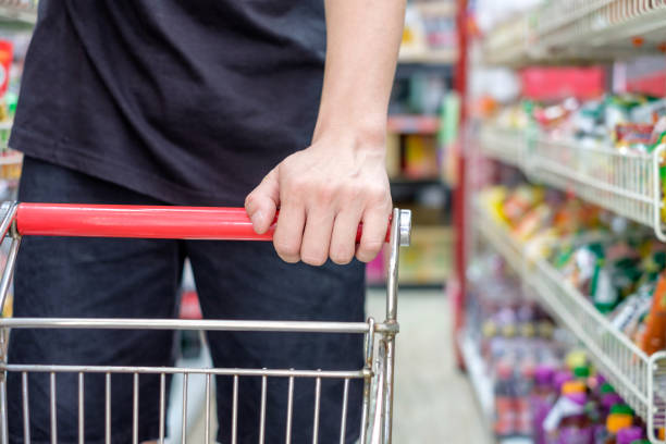 istock Customer with shopping cart choosing product in store 908182502
