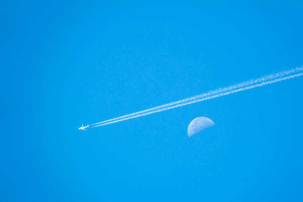 Airplane flying pass moon on day blue sky is beauty