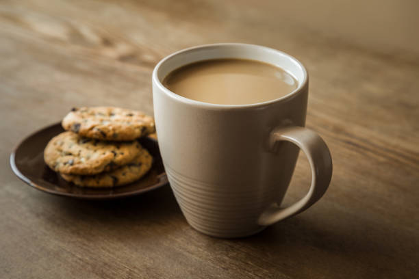 cup of coffee with milk and cookies with chocolate pieces on the brown wooden table. resting and enjoying time with coffee and sweets. drink and snack concept. - caffeine free imagens e fotografias de stock