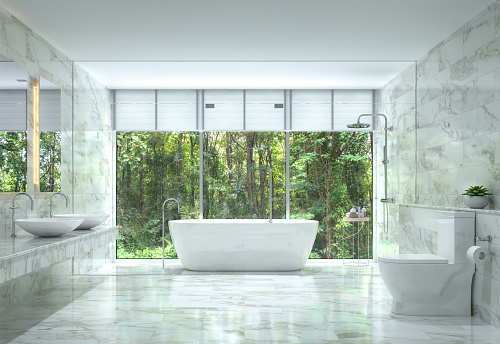 Modern luxury bathroom with nature view 3d rendering image. There are white marble tile wall and floor.The room has large windows. Looking out to see the nature.