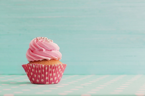 pink cupcake on blue wooden background
