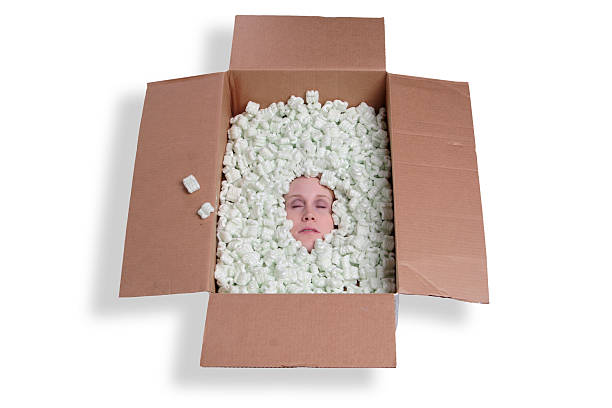 Buried Concept image of a freaky head burried in a box of packaging peanuts. gawp stock pictures, royalty-free photos & images