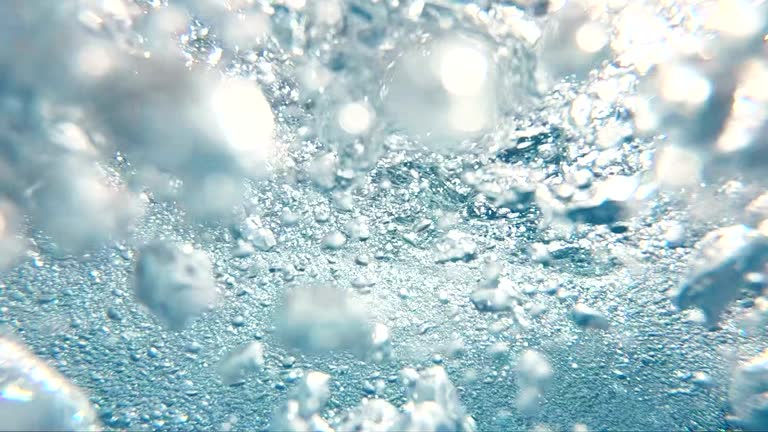 Big blue underwater bubbles rising to surface in slow motion