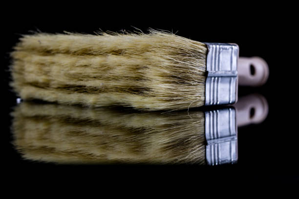 istock A paintbrush for a painter on a glass table. Painting accessories in a mirror reflection. Black background. 908219712