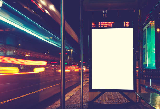 illuminated blank billboard with copy space for your text message or content, advertising mock up banner of bus station, public information board with blurred vehicles in high speed in night city - bus station imagens e fotografias de stock