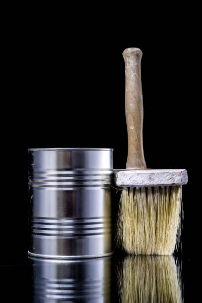 istock A paintbrush for a painter on a glass table. Painting accessories in a mirror reflection. Black background. 908221018