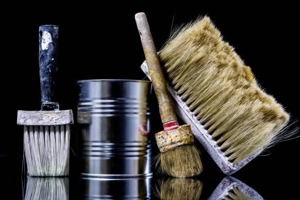 istock A paintbrush for a painter on a glass table. Painting accessories in a mirror reflection. Black background. 908221030